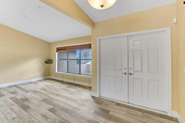 foyer with lofted ceiling and light hardwood / wood-style flooring