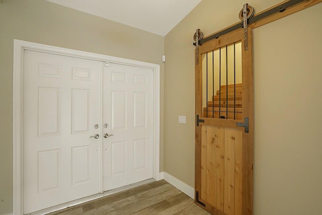 entrance foyer with a barn door and hardwood / wood-style flooring