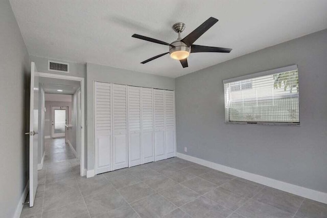 632 Monaco N, Delray Beach, FL 33446 - unfurnished bedroom with multiple windows, baseboards, a closet, and a ceiling fan