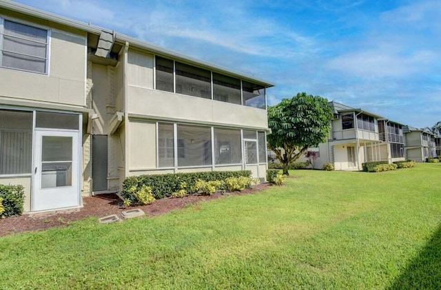 632 Monaco N, Delray Beach, FL 33446 - back of house with a yard, a sunroom, and stucco siding