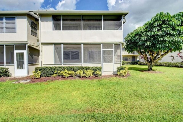 632 Monaco N, Delray Beach, FL 33446 - back of house with a sunroom, a lawn, and stucco siding