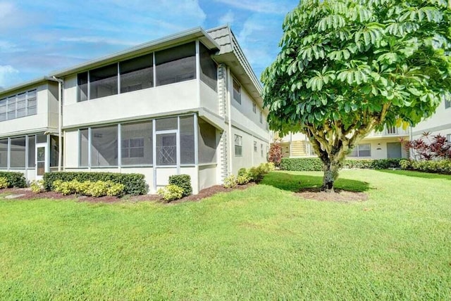 632 Monaco N, Delray Beach, FL 33446 - view of property exterior featuring a sunroom, a yard, and stucco siding