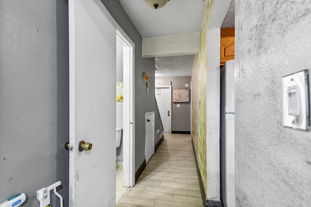 hallway with a barn door and light hardwood / wood-style floors