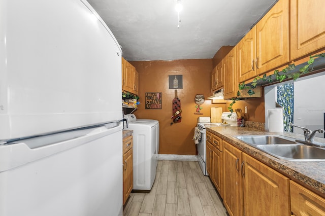 kitchen featuring washer / dryer, white appliances, sink, and light hardwood / wood-style flooring