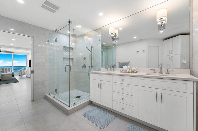 bathroom with vanity, an enclosed shower, a water view, and tile patterned flooring