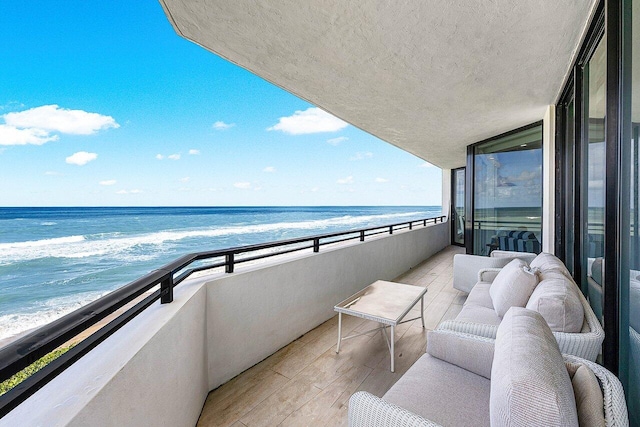 balcony featuring a water view and a beach view