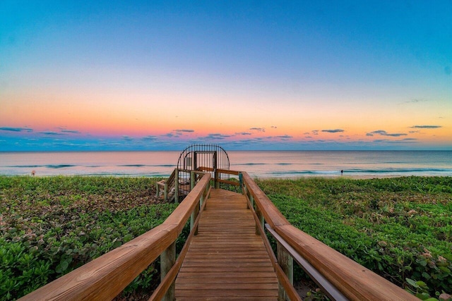 exterior space with a water view and a beach view