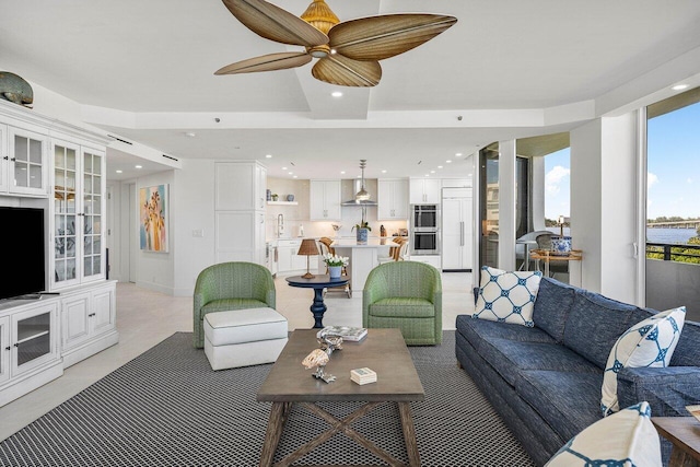 living room featuring ceiling fan and sink