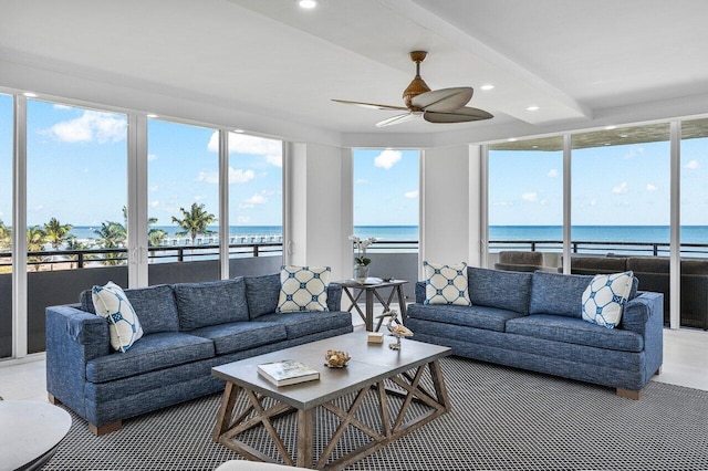 sunroom / solarium featuring a water view and ceiling fan