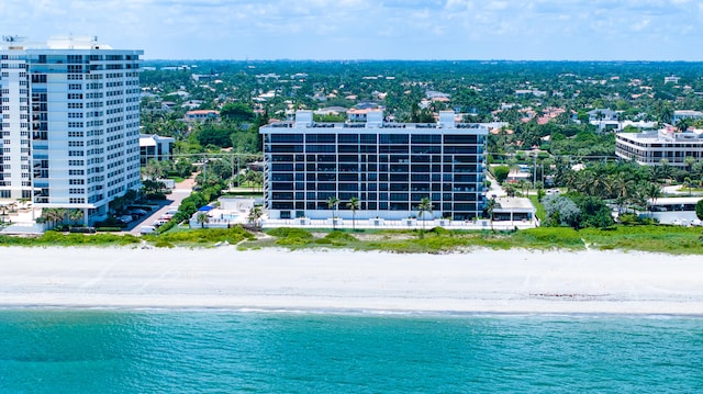 drone / aerial view with a water view and a beach view