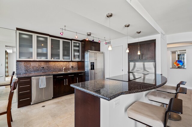 1800 S Ocean Blvd Unit 5C, Boca Raton, FL 33432 - kitchen with stainless steel appliances, a breakfast bar area, a sink, backsplash, and dark brown cabinets