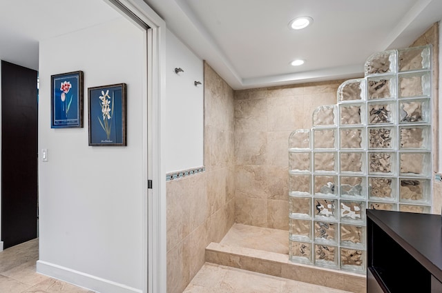 bathroom featuring a tile shower, vanity, and tile patterned floors