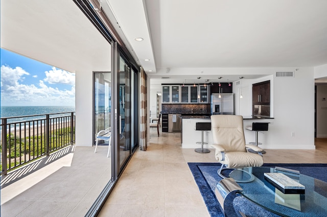 living room with a water view and light tile patterned floors