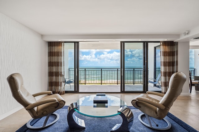 living room featuring expansive windows, light tile patterned flooring, and a water view