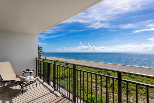 balcony featuring a water view and a beach view