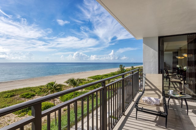 balcony featuring a water view and a beach view