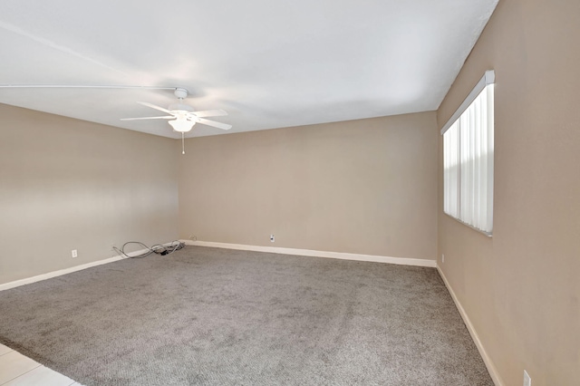 carpeted spare room featuring ceiling fan