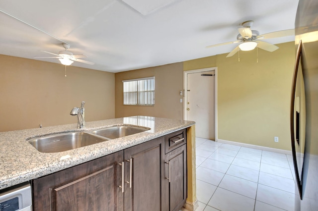 kitchen featuring stainless steel fridge with ice dispenser, sink, light tile patterned floors, ceiling fan, and light stone counters