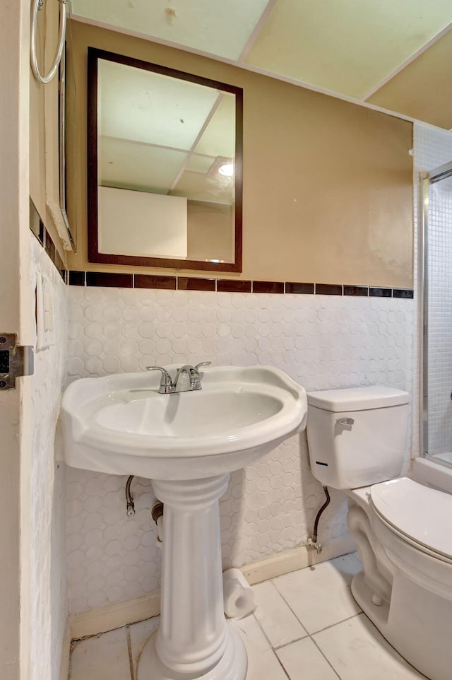 bathroom with tile walls, tile patterned flooring, and toilet