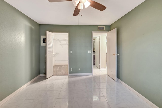 unfurnished bedroom featuring ceiling fan, a closet, and a walk in closet