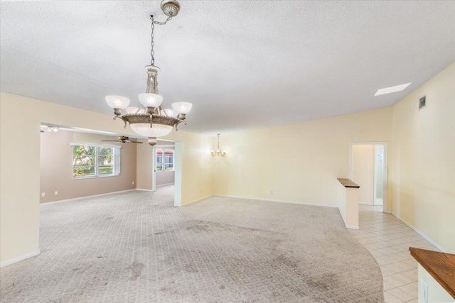 unfurnished room with a textured ceiling, vaulted ceiling, light colored carpet, and ceiling fan with notable chandelier