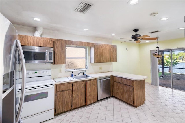 kitchen featuring kitchen peninsula, sink, a healthy amount of sunlight, and appliances with stainless steel finishes