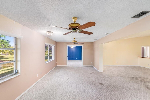 carpeted spare room with ceiling fan and a textured ceiling