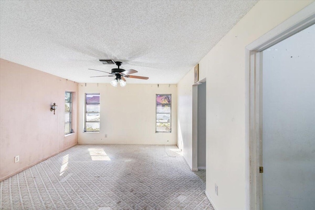 carpeted empty room featuring a textured ceiling and ceiling fan