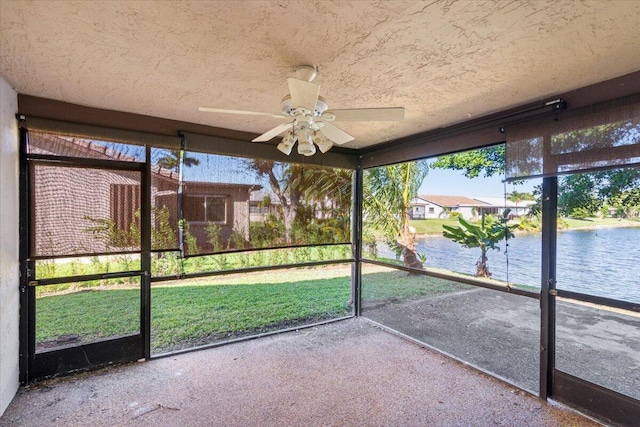 unfurnished sunroom with a water view and ceiling fan