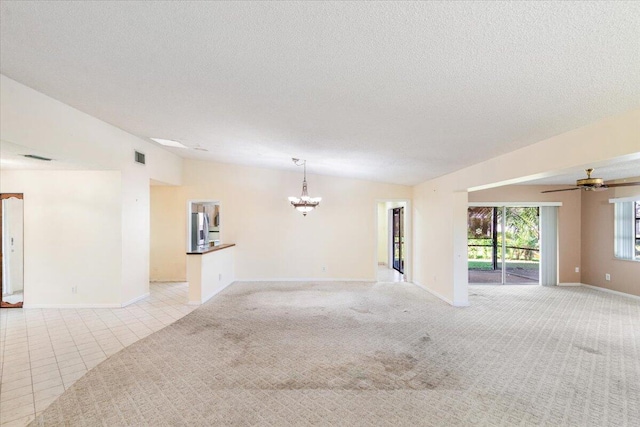 carpeted empty room featuring a textured ceiling and ceiling fan with notable chandelier