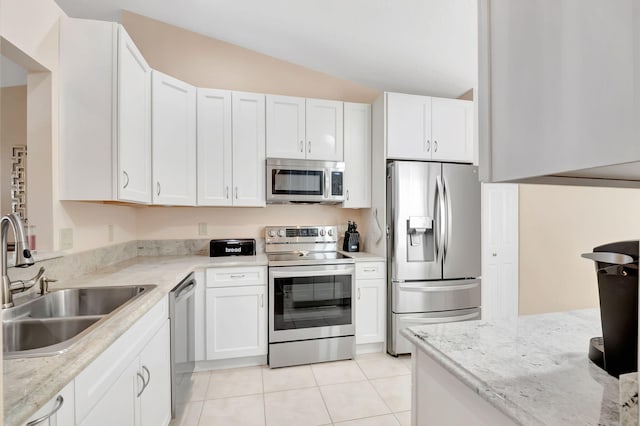 kitchen featuring sink, white cabinets, stainless steel appliances, and light tile patterned floors