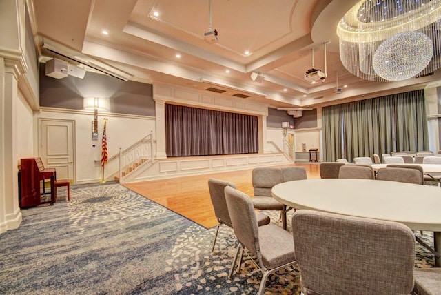 home theater with a raised ceiling and wood-type flooring