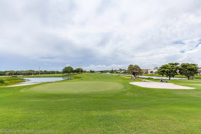 surrounding community featuring a water view and a lawn