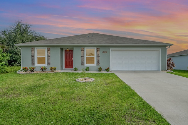 ranch-style house with a garage and a yard