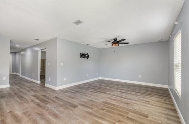 empty room with light hardwood / wood-style floors and ceiling fan