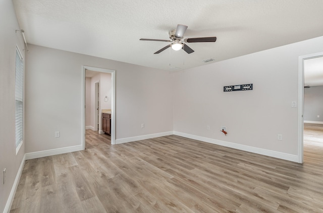 spare room featuring a textured ceiling, light hardwood / wood-style flooring, and ceiling fan