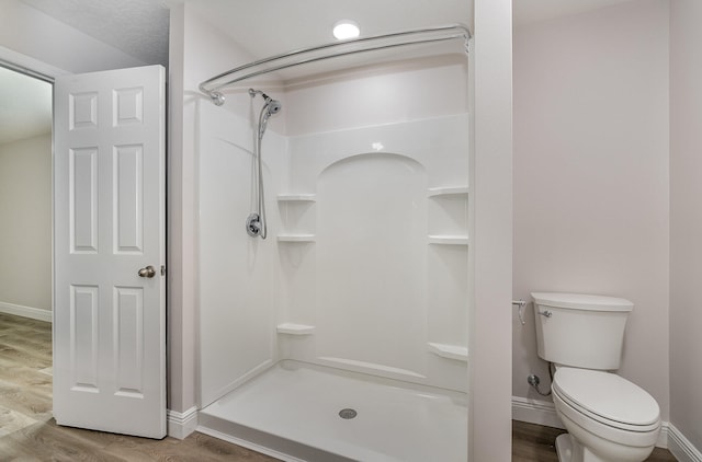 bathroom with walk in shower, wood-type flooring, and toilet