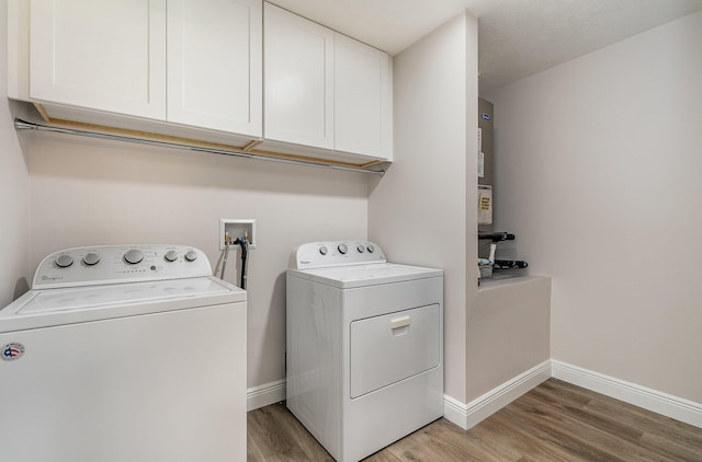 laundry room featuring light wood-type flooring, cabinets, and independent washer and dryer