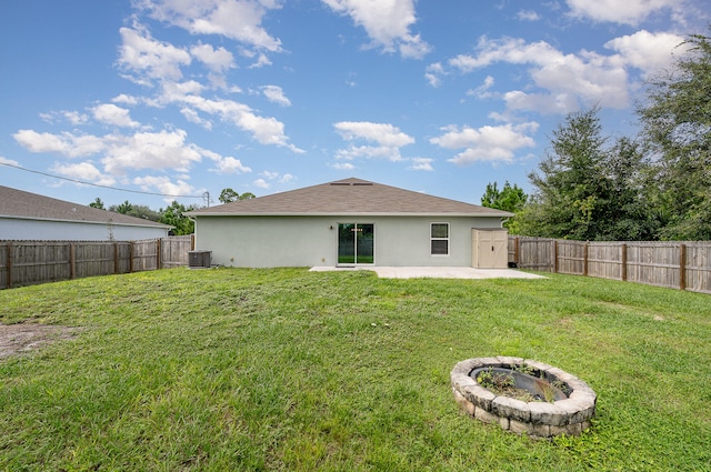 back of house featuring a patio, central AC, a yard, and a fire pit