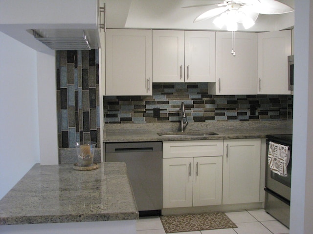 kitchen featuring white cabinetry, sink, backsplash, light tile patterned flooring, and appliances with stainless steel finishes