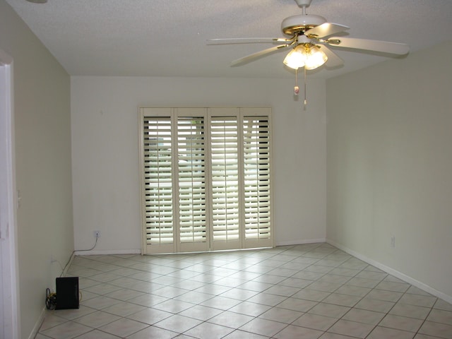 unfurnished room with light tile patterned floors, a textured ceiling, ceiling fan, and a healthy amount of sunlight