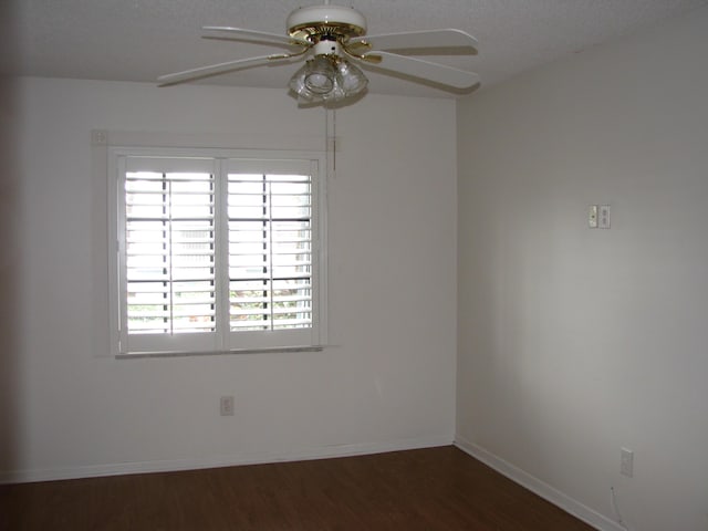 empty room featuring a textured ceiling, ceiling fan, and dark wood-type flooring