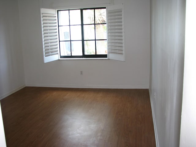 spare room with dark wood-type flooring