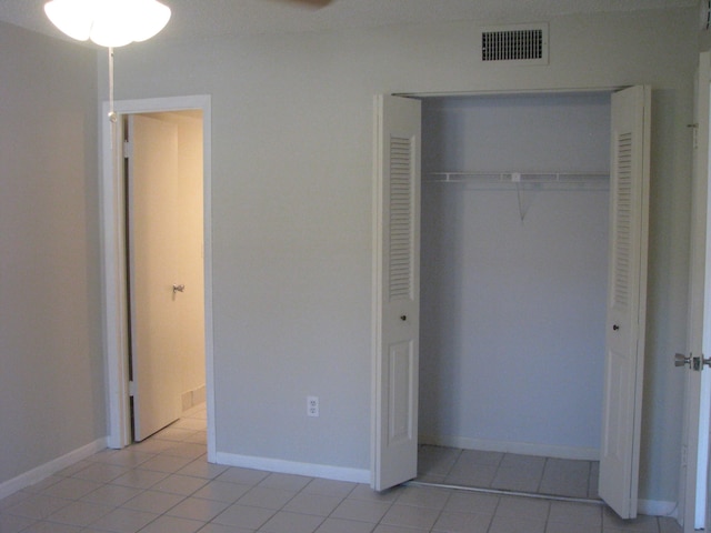 unfurnished bedroom featuring light tile patterned flooring and a closet