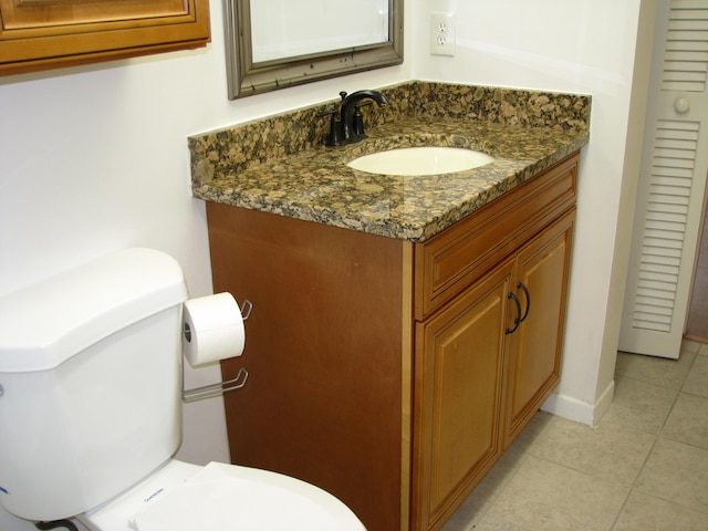 bathroom featuring tile patterned flooring, vanity, and toilet