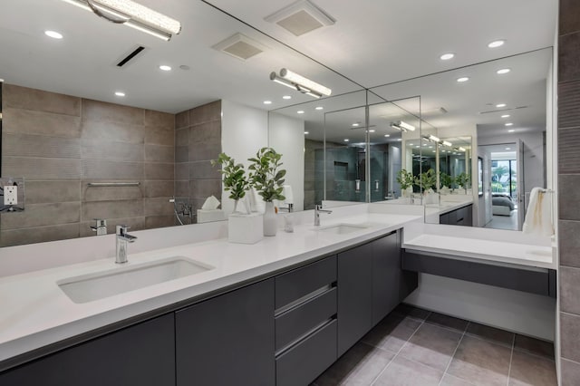 bathroom featuring tile patterned floors, vanity, an enclosed shower, and tile walls