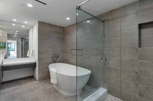 bathroom featuring tile patterned flooring, vanity, tile walls, and independent shower and bath