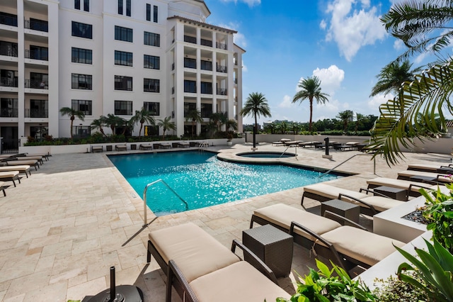 view of pool with a hot tub and a patio area