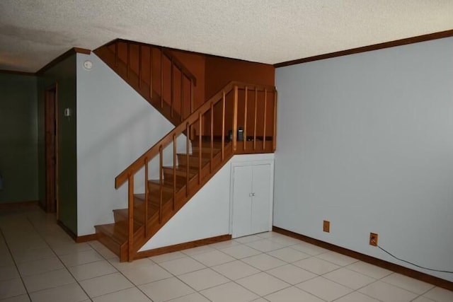 stairway with ornamental molding and a textured ceiling