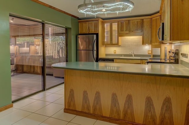 kitchen featuring decorative backsplash, appliances with stainless steel finishes, crown molding, sink, and light tile patterned floors